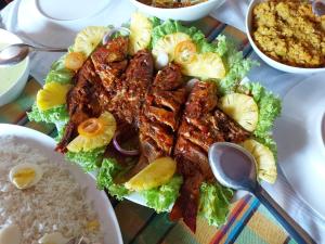 een bord met vlees en rijst op tafel bij Queens Hotel in Udawalawe