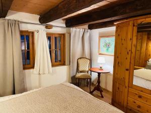 a bedroom with a bed and a table and a chair at Chalet Rayon de Soleil in Gryon