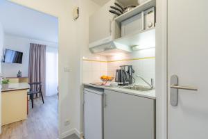 a kitchen with a sink and a counter top at Appart'City Classic Caen in Caen