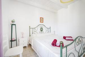 a white bedroom with a white bed and a chair at Casina delle Rose - Scirocco in Polignano a Mare