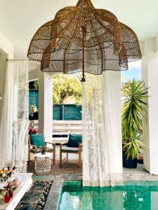 an umbrella over a swimming pool in a house at Chambres d'hôtes & spa Le Jardin de Ravintsara in Ravine des Cabris