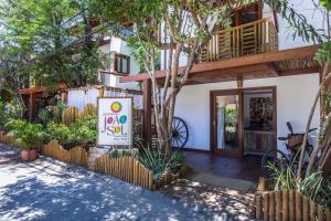 a house with a sign in front of it at Pousada João Sol in Praia do Forte