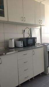 a kitchen with white cabinets and a microwave at Newly equipped Arena apartment in Belgrade