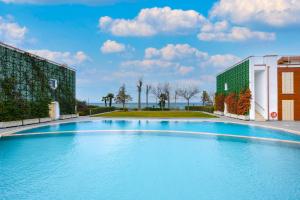 una grande piscina blu accanto a un edificio di Borgo Gasparina Family Apartments a Castelnuovo del Garda