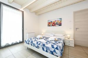 una camera con un letto blu e bianco e una finestra di Borgo Gasparina Family Apartments a Castelnuovo del Garda