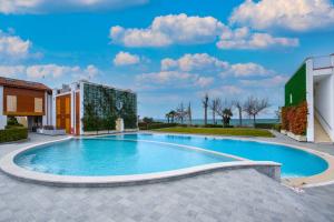 duży basen w podwórzu z budynkiem w obiekcie Borgo Gasparina Family Apartments w mieście Castelnuovo del Garda