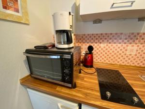 eine Kaffeemaschine auf der Mikrowelle auf der Theke in der Unterkunft Gästehaus Schmitt in Appenheim