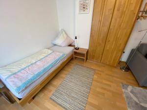 a small bedroom with a bed and a television at Gästehaus Schmitt in Appenheim