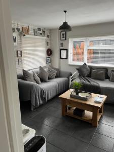 a living room with a couch and a coffee table at Herb Garden Bungalow in Nazeing