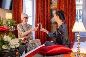 een man en een vrouw die wijn drinken in een kamer bij Hotel De Seine in Parijs