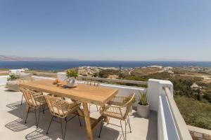 a wooden table and chairs on a balcony with the ocean at Solasta Residence in Márpissa