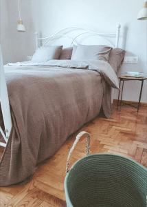 Una cama en un dormitorio con una silla al lado en Vintage Apartment mit Herz, en Pyrgadikia