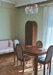 comedor con mesa de madera y sillas en Vintage Apartment mit Herz, en Pyrgadikia
