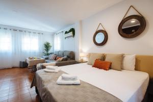 a bedroom with a large bed and a living room at SAH23 beautiful studio in the center in Seville