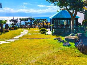 OROJEJU في سيوجويبو: شرفة مع الصخور في العشب بالقرب من المحيط
