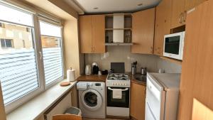 a small kitchen with a washing machine and a washer at HYGGE Apartment CONTACTLESS CHECK-IN in Šiauliai