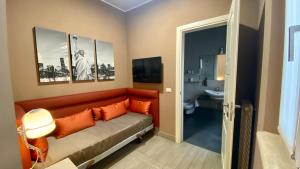 ネットゥーノにあるHalex room&foodのソファ(オレンジ色の枕付)、バスルームが備わる客室です。