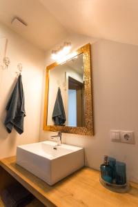 uma casa de banho com um lavatório branco e um espelho. em Brīvdienu māja Saule em Mersrags