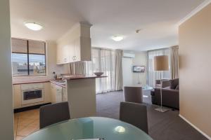a kitchen and living room with a table and chairs at West End Central Apartments in Brisbane