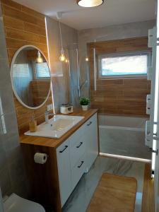 a bathroom with a sink and a mirror and a tub at Apartament 4U - Azyl Arkadia in Suwałki