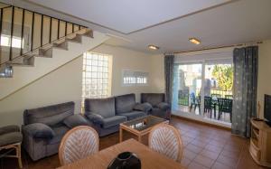 - un salon avec des canapés, un canapé et une table dans l'établissement Adosado familiar frente a la piscina - Palm Beach ALBERT VILLAS Alcossebre, à Alcossebre