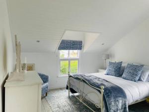 biała sypialnia z łóżkiem i oknem w obiekcie Quaint Gowrie Village Apartment w mieście Nottingham Road