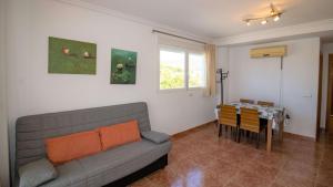 een woonkamer met een bank en een tafel bij Atico en primera línea con vistas al mar - Roquer Marti ALBERT VILLAS in Alcossebre