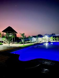 a blue swimming pool at night with a gazebo at Bluewave Farm Villa in Louis Trichardt