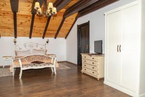 - une chambre avec un lit, une commode et une télévision dans l'établissement Cabana Perla Durau, à Durau