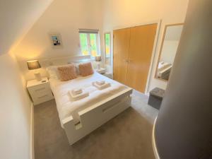a bedroom with a white bed and a large mirror at Trewhiddle Villa 30 in St Austell