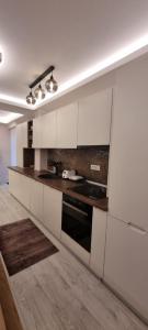 a kitchen with white cabinets and a stove top oven at Alexys Top Residence Predeal in Predeal