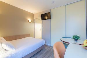 Habitación de hotel con cama y mesa en Appart'City Confort Nantes Cité des Congrès en Nantes