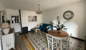 uma sala de estar com uma mesa e um sofá azul em Chez Tatie Ménie em Fraissé-des-Corbières