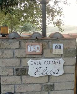 a brick wall with a sign on top of it at Casa Vacanze Elisa in Manciano