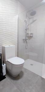 a white bathroom with a toilet and a shower at Costa Adeje Ocean View Apartment in Adeje