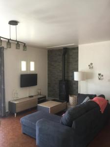 a living room with a blue couch and a fireplace at La Perline, Maison individuelle - 4 à 6 personnes in Le Crestet