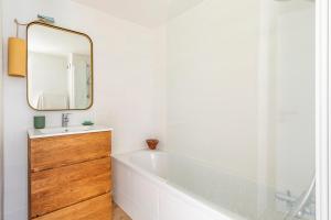 łazienka z białą wanną i lustrem w obiekcie Nature & Sun, Natural lifestyle - Hossegor w mieście Soorts-Hossegor