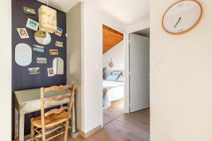 sypialnia ze stołem i zegarem na ścianie w obiekcie Nature & Sun, Natural lifestyle - Hossegor w mieście Soorts-Hossegor