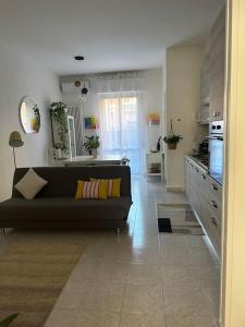 ein Wohnzimmer mit einem Sofa und einer Küche in der Unterkunft Appartamento Mirsie in Bologna