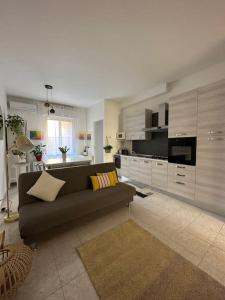 ein Wohnzimmer mit einem Sofa und einer Küche in der Unterkunft Appartamento Mirsie in Bologna