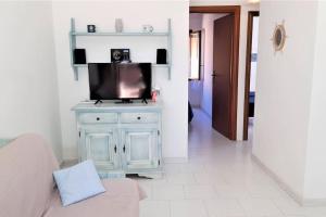 a living room with a tv on top of a cabinet at Casa Mare, Villaggio Galanu in Costa Paradiso