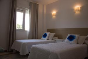 um quarto de hotel com duas camas e uma janela em Bellavista Bolonia em Bolonia
