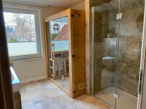 a bathroom with a shower and a glass door at Traumhaus Wernigerode mit Sauna und Kamin in Wernigerode +54 photos