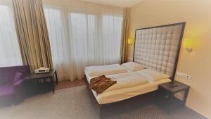 a bedroom with a bed with a large headboard at Styles Hotel Munich in Munich