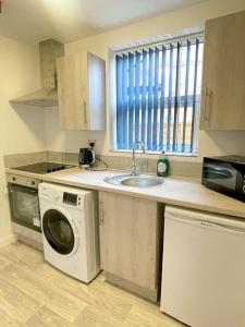 a kitchen with a washing machine and a sink at 2.Superb Serviced Apartment - free on road parking in Birmingham