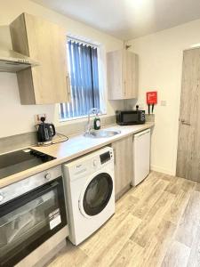 a kitchen with a washing machine and a sink at 2.Superb Serviced Apartment - free on road parking in Birmingham