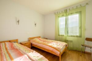 um quarto com 2 camas e uma janela em Patufet - Charmante maison 6 personnes em Fontrabiouse