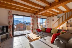 a living room with a couch and a large window at Patufet - Charmante maison 6 personnes in Fontrabiouse