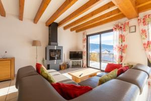 a living room with a couch and a large window at Patufet - Charmante maison 6 personnes in Fontrabiouse
