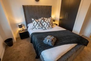 a bedroom with a bed with a bag on it at JPG Theatre Suite - High Floor MCR Luxe Apartment w Balcony Canal Views in Manchester